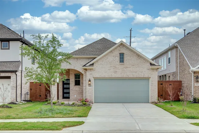 a front view of a house with a garden and yard