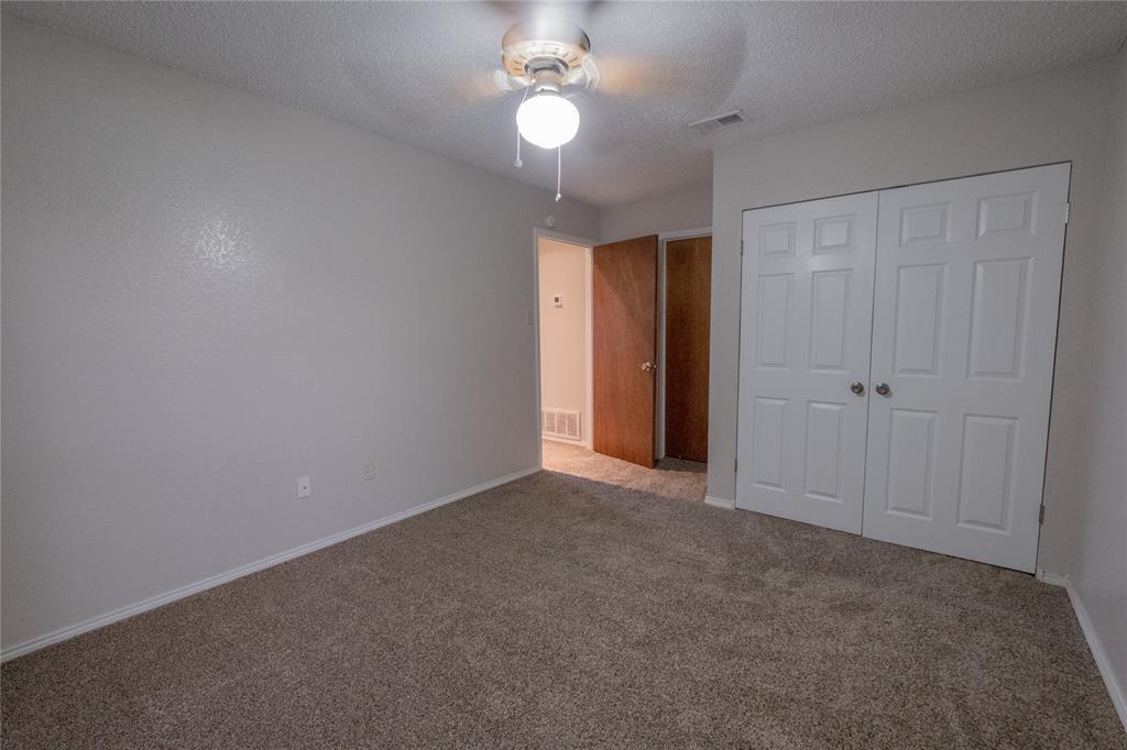 675 Harbor Drive North, Unit C Azle, TX 76020 - Photo 16 of 19 an empty room with a chandelier fan and windows