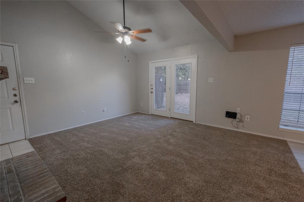 675 Harbor Drive North, Unit C Azle, TX 76020 - Photo 9 of 19 an empty room with chandelier fan and windows