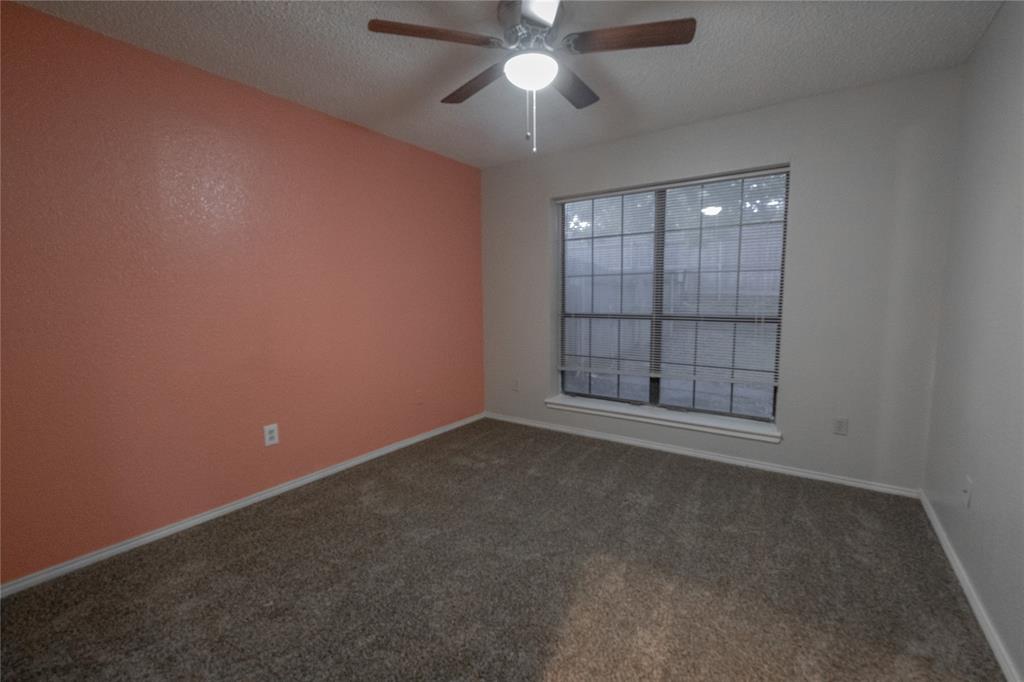 675 Harbor Drive North, Unit C Azle, TX 76020 - Photo 10 of 19 an empty room with chandelier fan and windows