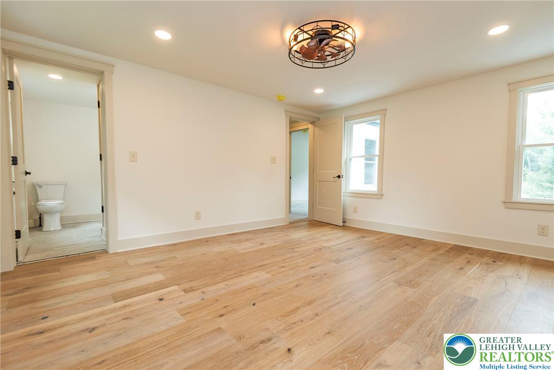 72 Allegheny Road Mount Bethel, PA 18343 - Photo 28 of 72 A tranquil primary bedroom with warm hardwood floors and a striking ceiling fan.