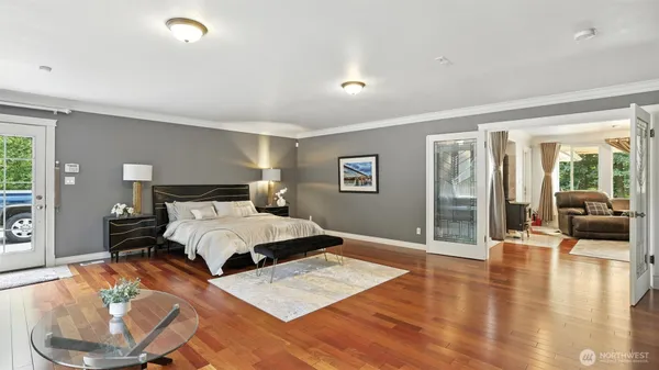 a bedroom with a large bed and a wooden floor