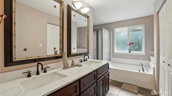 a bathroom with a tub a sink and mirror