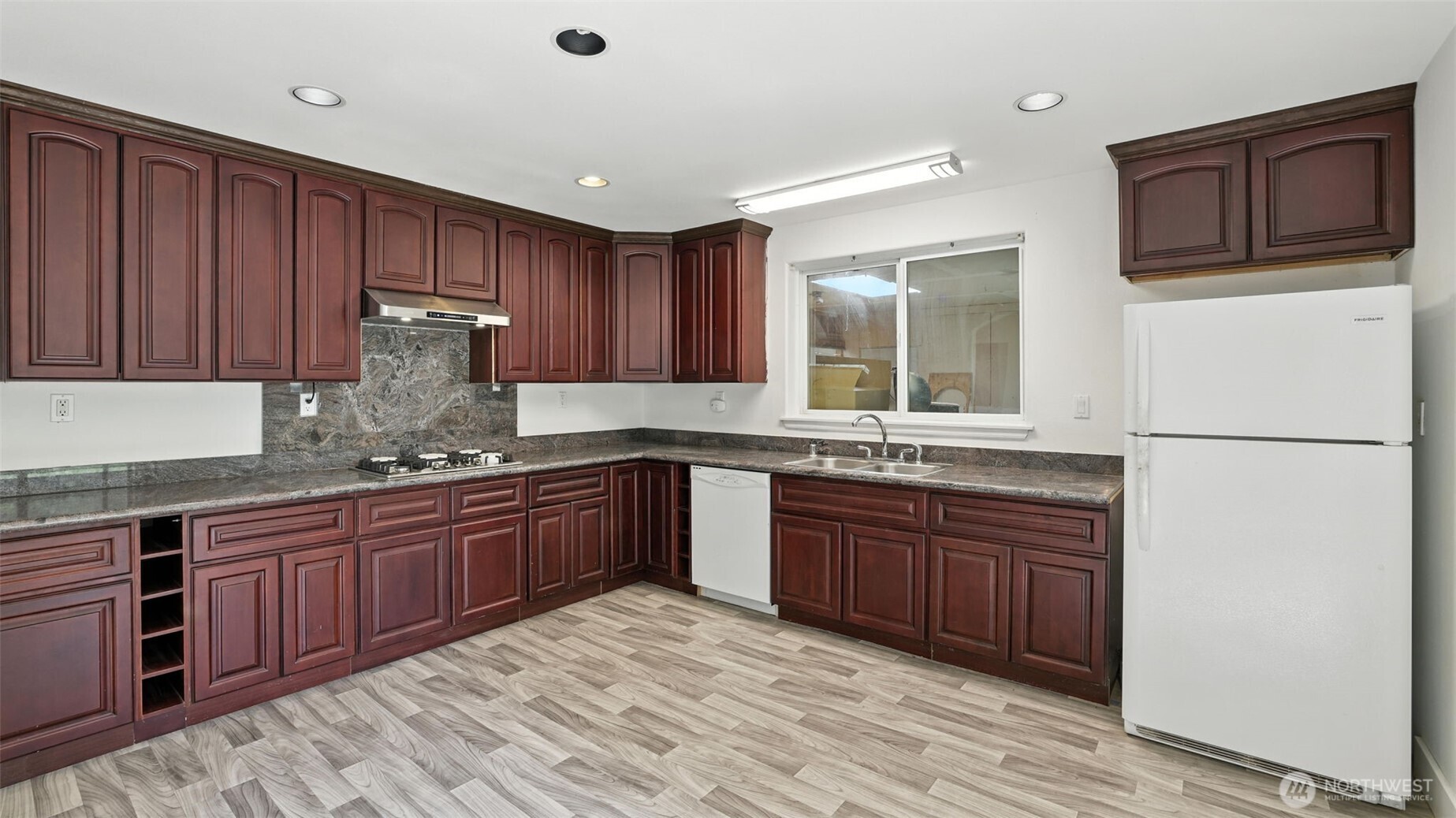 18911 Southeast 144th Street Renton, WA 98059 - Photo 31 of 39 a kitchen with stainless steel appliances granite countertop wooden cabinets a stove top oven and granite counter tops