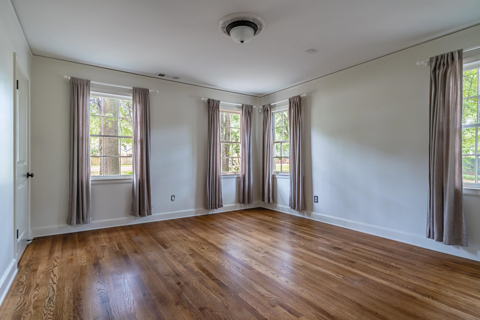 5022 Walnut Grove Road Memphis, TN 38117 - Photo 13 of 33 a view of an empty room with wooden floor and a window