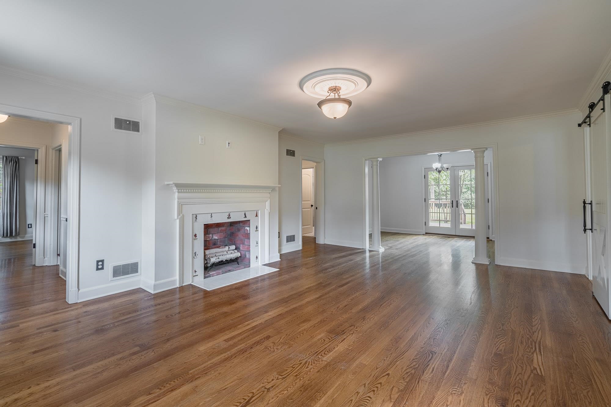 5022 Walnut Grove Road Memphis, TN 38117 - Photo 5 of 33 an empty room with wooden floor fireplace and windows