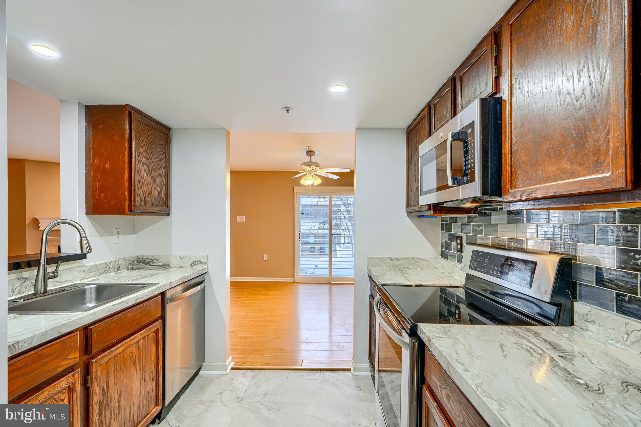 14235 Jib Street, Unit 7342 Laurel, MD 20707 - Photo 6 of 25 a kitchen with stainless steel appliances granite countertop a sink stove and refrigerator