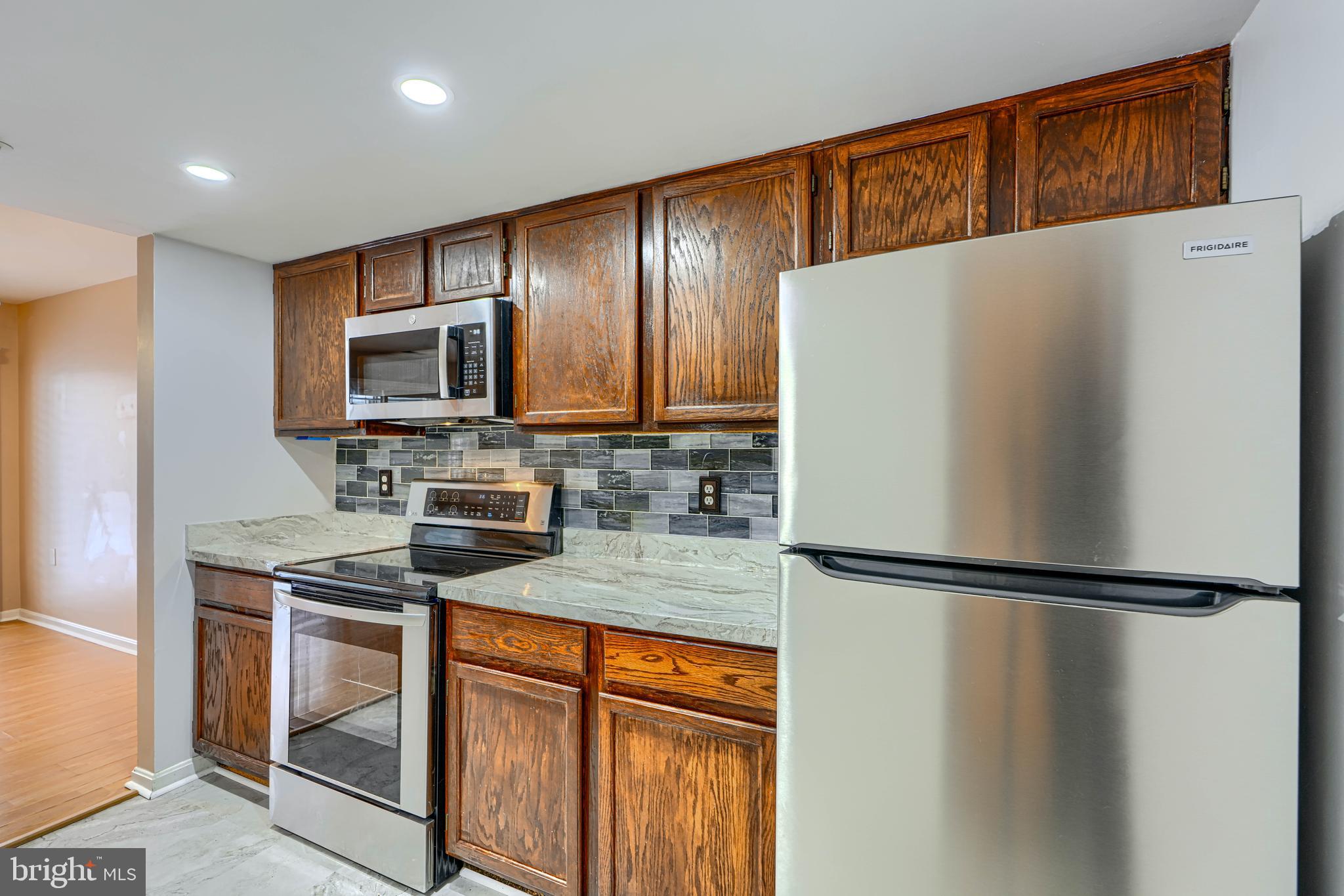 14235 Jib Street, Unit 7342 Laurel, MD 20707 - Photo 9 of 25 a kitchen with stainless steel appliances granite countertop a refrigerator sink and microwave