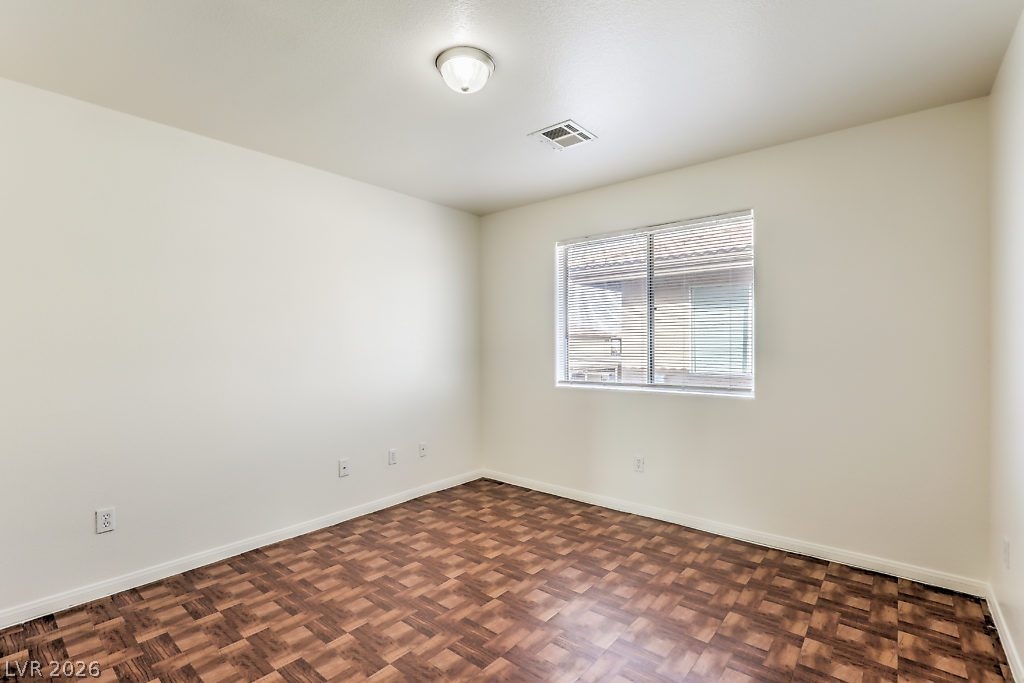 3127 North Walnut Road, Unit A Las Vegas, NV 89115 - Photo 11 of 12 A well-proportioned bedroom offers patterned vinyl flooring and natural light from a window with blinds.