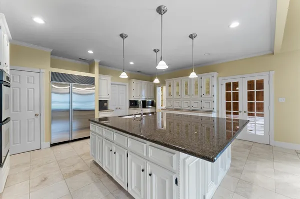 a large kitchen with kitchen island granite countertop a large counter top and stainless steel appliances