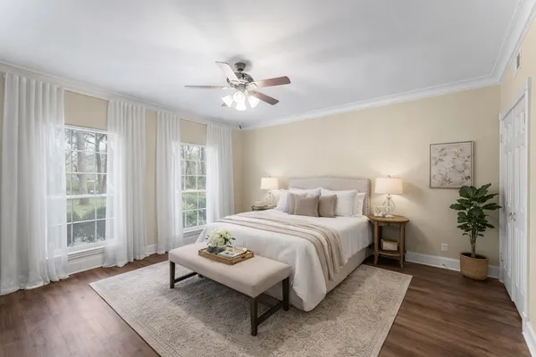 a bedroom with a large bed and wooden floor