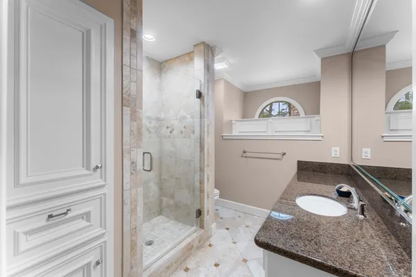 a bathroom with a granite countertop sink and shower