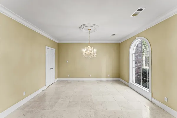 a view of a hallway with windows and chandelier
