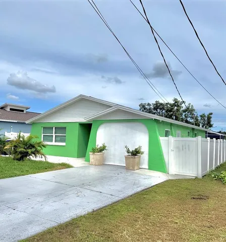 a view of a house with a yard and potted plants