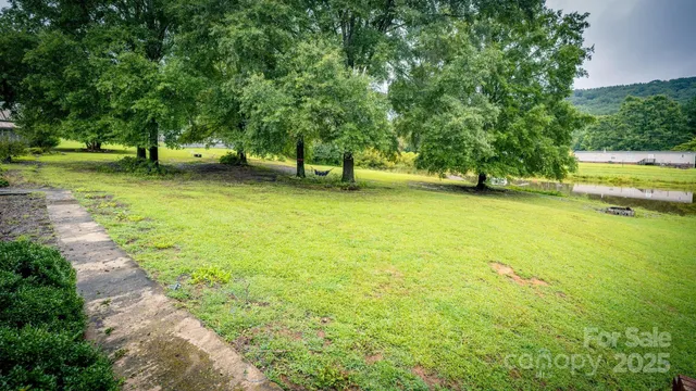 a kitchen with stainless steel appliances granite countertop a refrigerator a sink dishwasher a stove a dining table and chairs with wooden floor