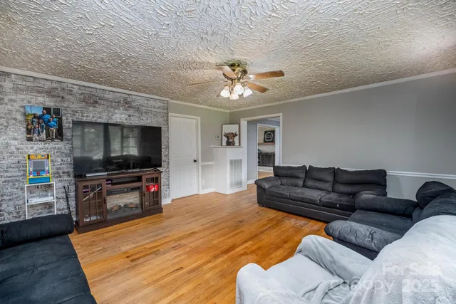 a view of empty room with wooden floor and fireplace