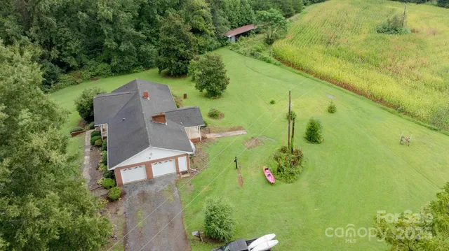 an aerial view of a house with a yard and lake view