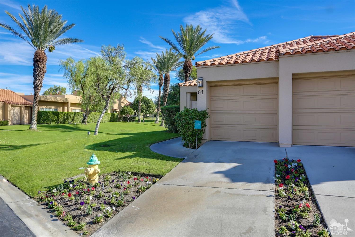 64 Oak Tree Drive Rancho Mirage, CA 92270 - Photo 1 of 31 a front view of a house with a yard