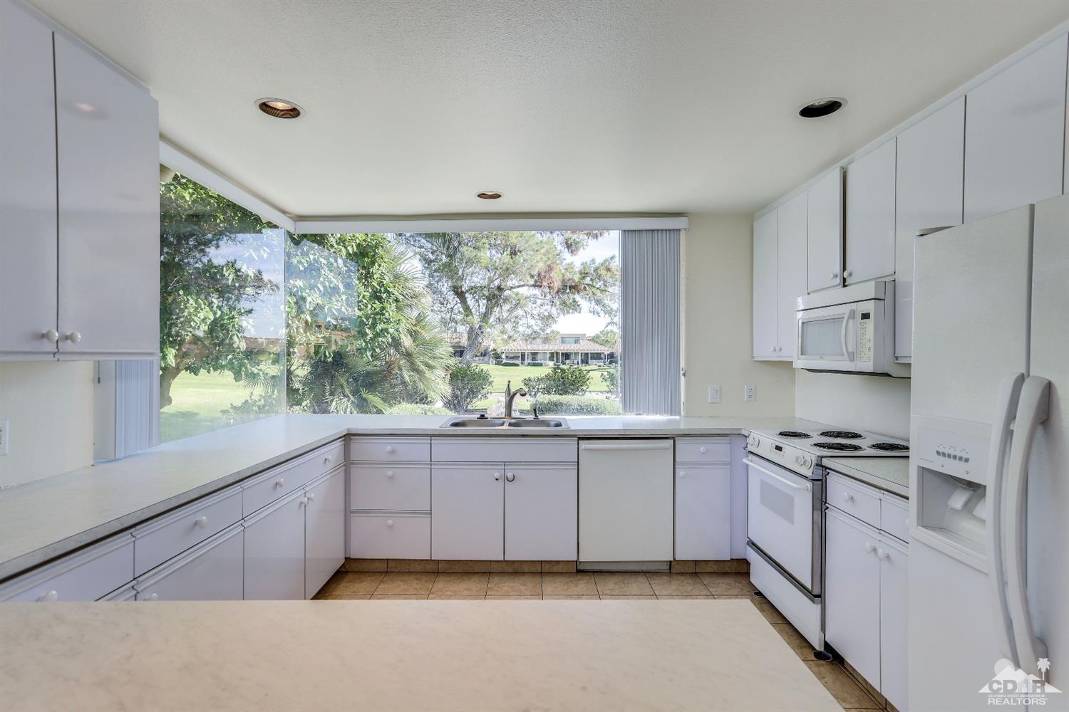 64 Oak Tree Drive Rancho Mirage, CA 92270 - Photo 16 of 31 a kitchen with stainless steel appliances granite countertop a stove a sink and a refrigerator