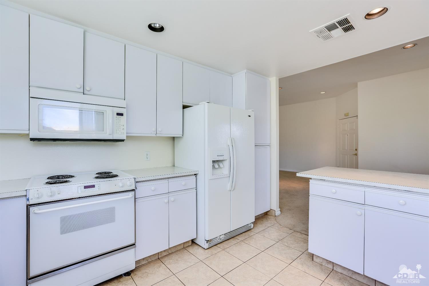 64 Oak Tree Drive Rancho Mirage, CA 92270 - Photo 18 of 31 a kitchen with white cabinets and white appliances