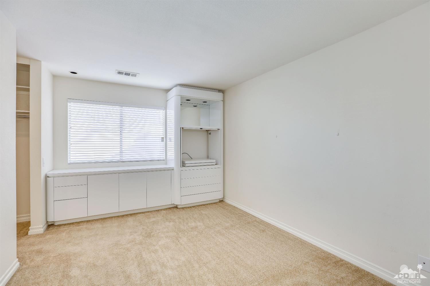 64 Oak Tree Drive Rancho Mirage, CA 92270 - Photo 19 of 31 a view of an empty room with a window