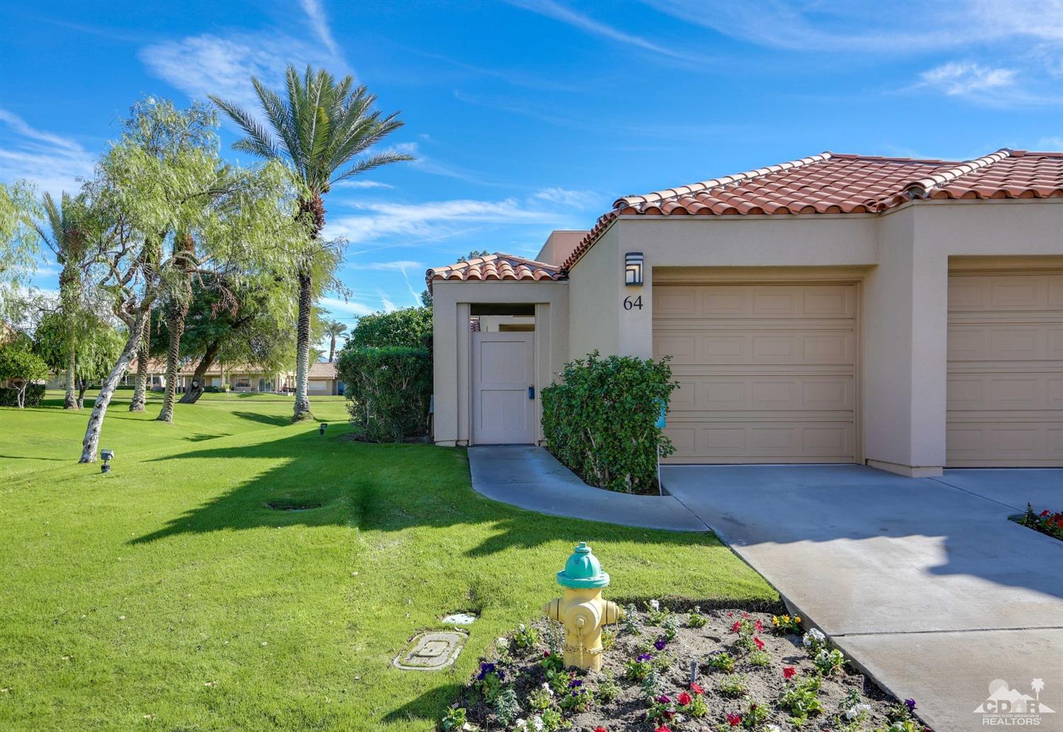 64 Oak Tree Drive Rancho Mirage, CA 92270 - Photo 2 of 31 a front view of a house with garden