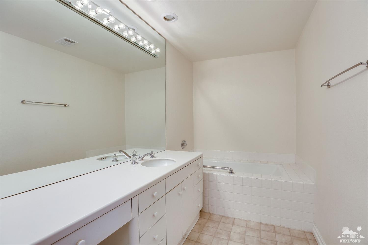 64 Oak Tree Drive Rancho Mirage, CA 92270 - Photo 24 of 31 a bathroom with a sink a mirror and a bathtub