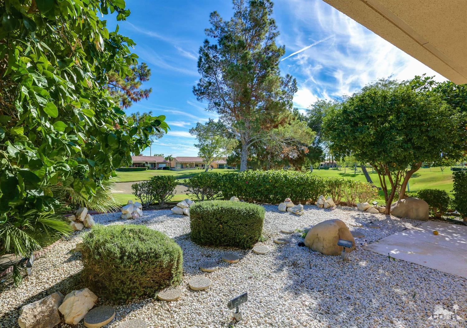 64 Oak Tree Drive Rancho Mirage, CA 92270 - Photo 27 of 31 a view of a backyard with table and chairs plants and large trees