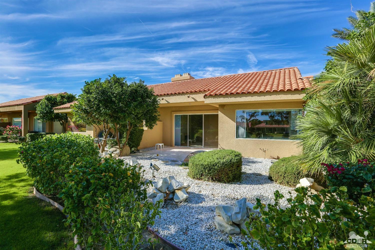 64 Oak Tree Drive Rancho Mirage, CA 92270 - Photo 28 of 31 a front view of a house with a garden
