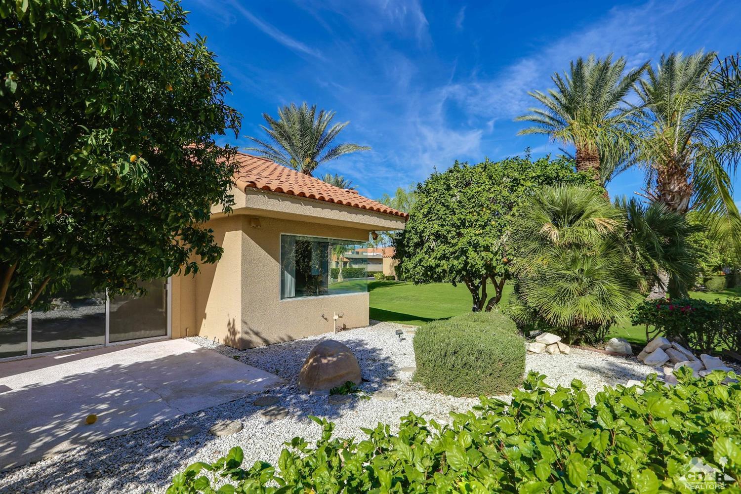 64 Oak Tree Drive Rancho Mirage, CA 92270 - Photo 29 of 31 a front view of a house with a yard and garage