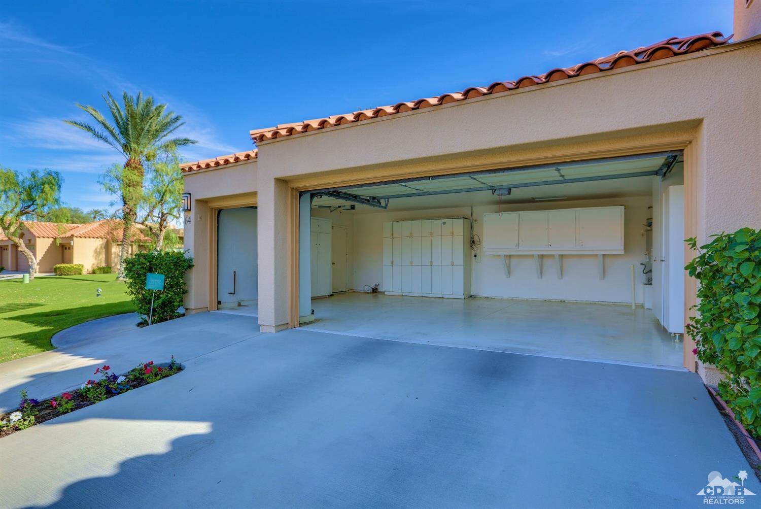 64 Oak Tree Drive Rancho Mirage, CA 92270 - Photo 7 of 31 front view of a house with a yard and a garage