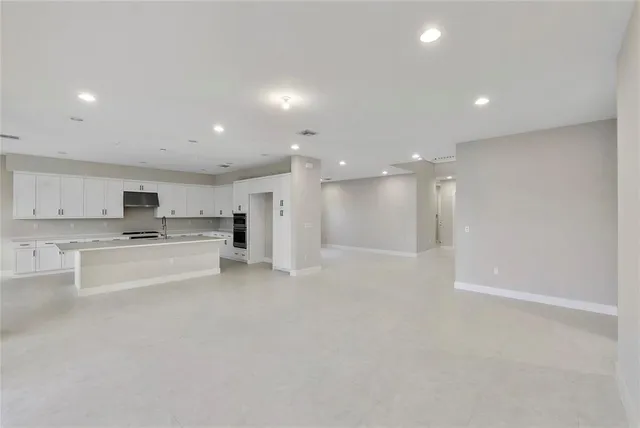a kitchen with stainless steel appliances a refrigerator sink stove and white cabinets