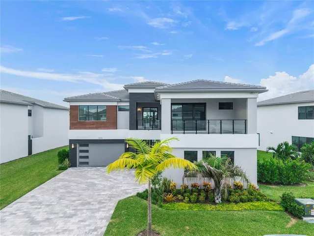 a front view of a house with a garden and plants