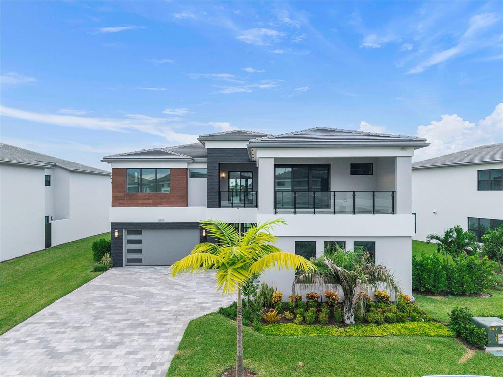 20119 Pacific Dunes Drive Boca Raton, FL 33434 - Photo 2 of 52 a front view of a house with a garden and plants