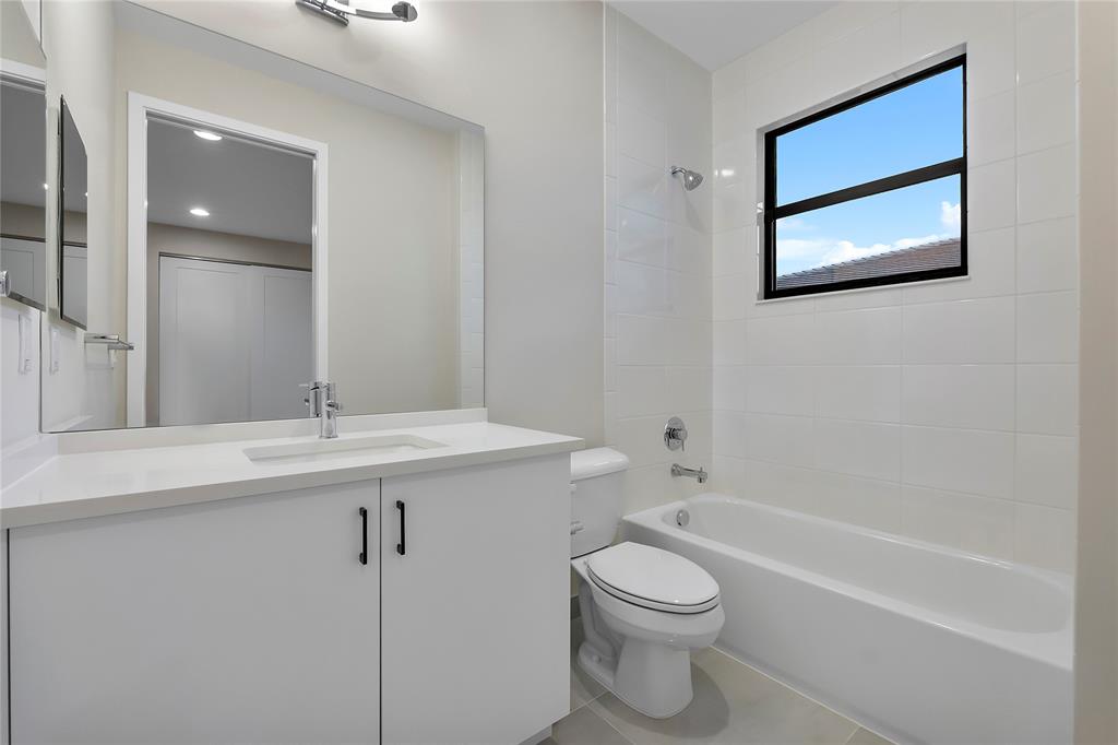 20119 Pacific Dunes Drive Boca Raton, FL 33434 - Photo 29 of 52 a bathroom with a toilet a sink a mirror and a bathtub