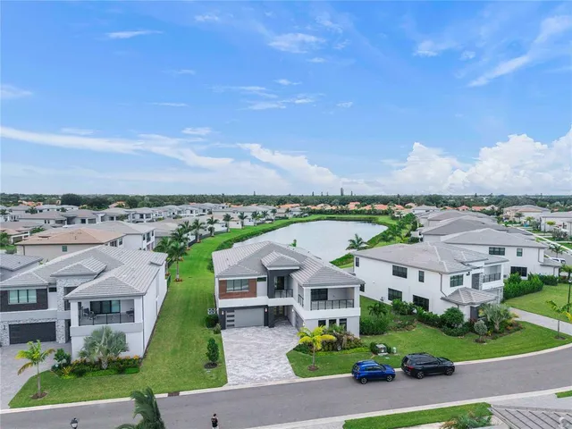 an aerial view of residential houses with yard and mountain view in back