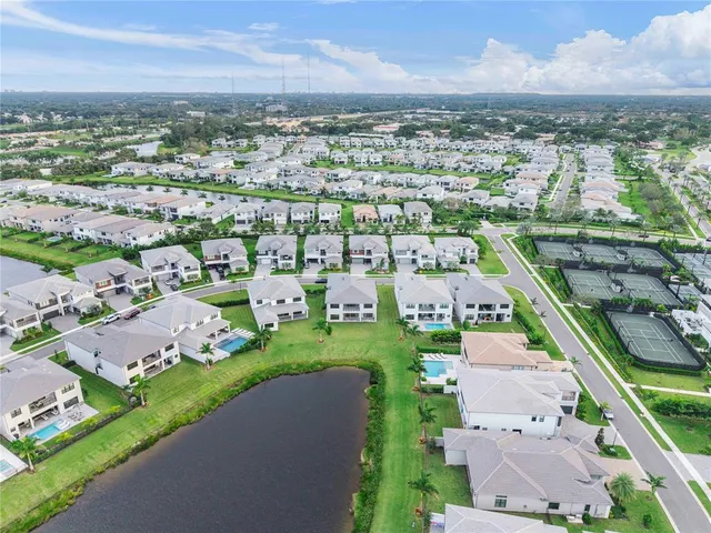 an aerial view of a city with lots of residential buildings ocean and mountain view in back
