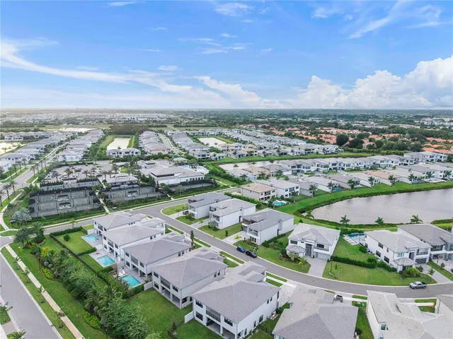 an aerial view of a city with lots of residential buildings ocean and mountain view in back