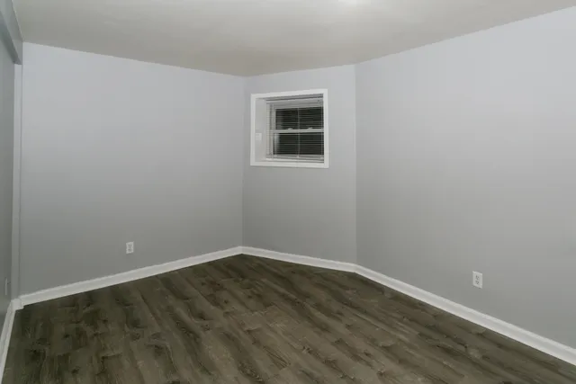 a view of a small space with wooden floor and a window
