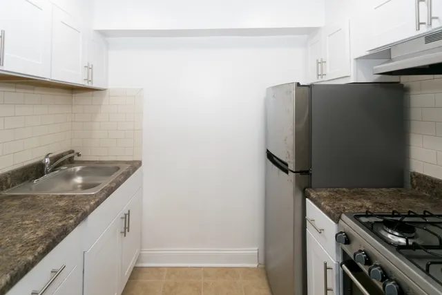 a kitchen with stainless steel appliances granite countertop a refrigerator and a sink