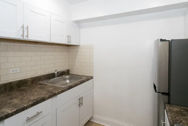 a sink with granite top and cabinets