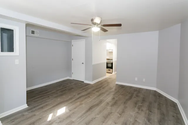 a view of empty room with wooden floor