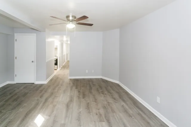 a view of a livingroom with a ceiling fan and wooden floor