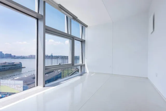 a view of a living room hardwood floor and a large window