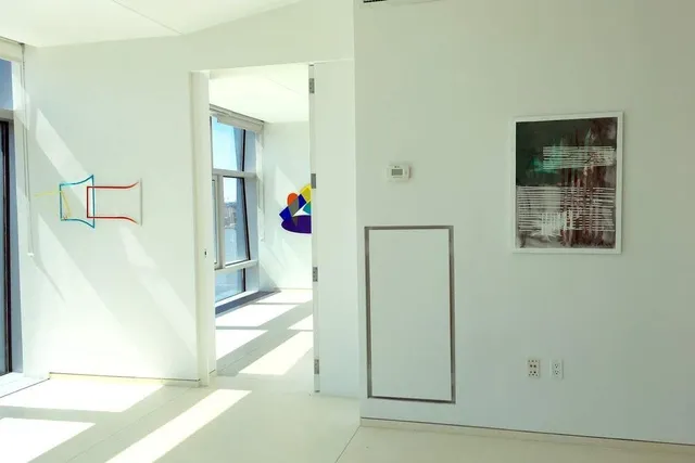 a view of a hallway with wooden floor and a living room