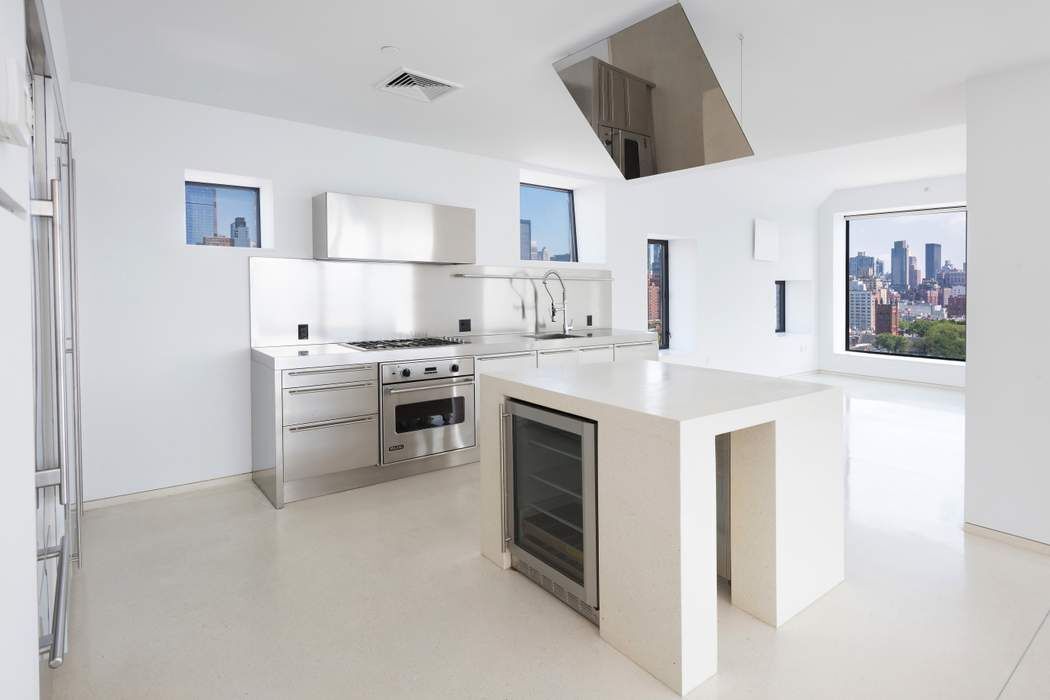 100 11th Avenue, Unit 16C Manhattan, NY 10011 - Photo 6 of 20 a kitchen with a stove top oven sink and cabinets