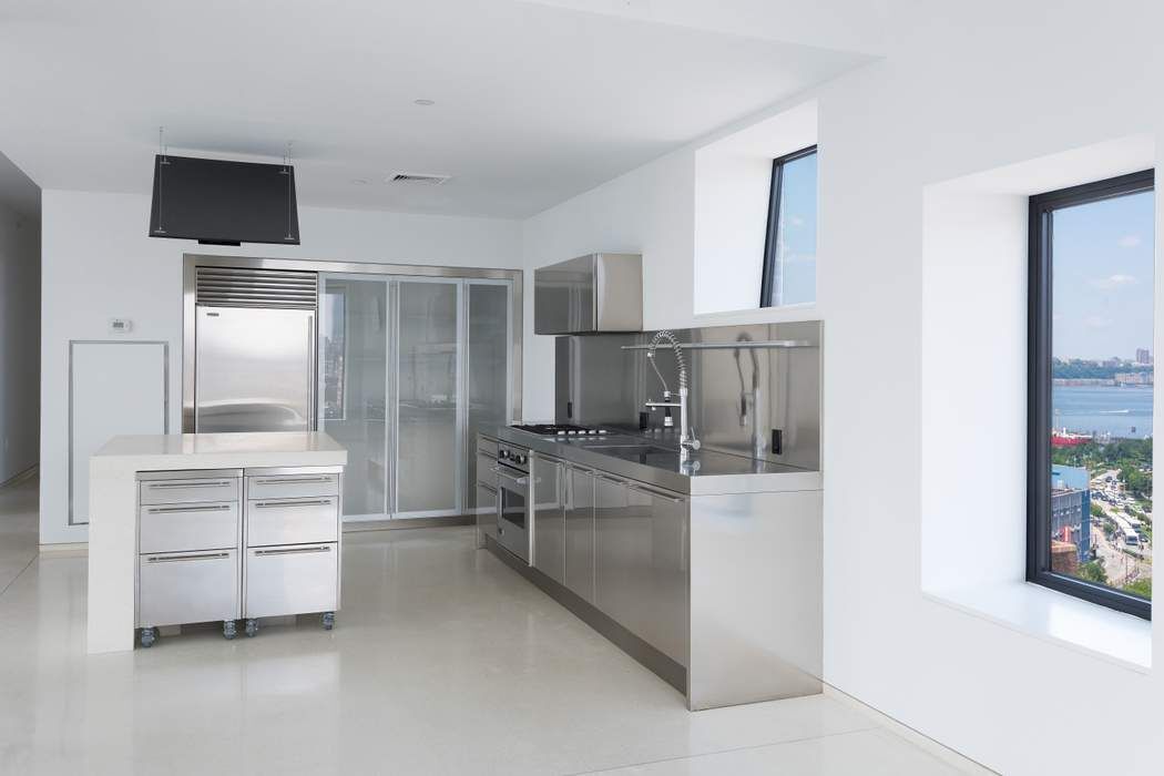 100 11th Avenue, Unit 16C Manhattan, NY 10011 - Photo 7 of 20 a kitchen with white cabinets and stainless steel appliances