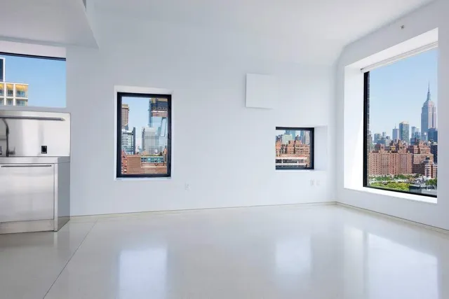 an empty room with windows and cabinet