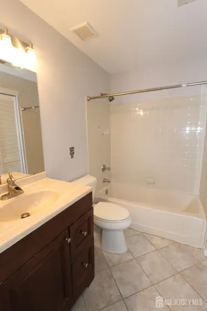 a bathroom with a double vanity sink toilet mirror and bathtub