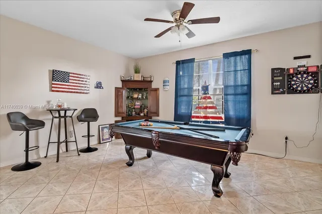 a room with furniture pool table and windows